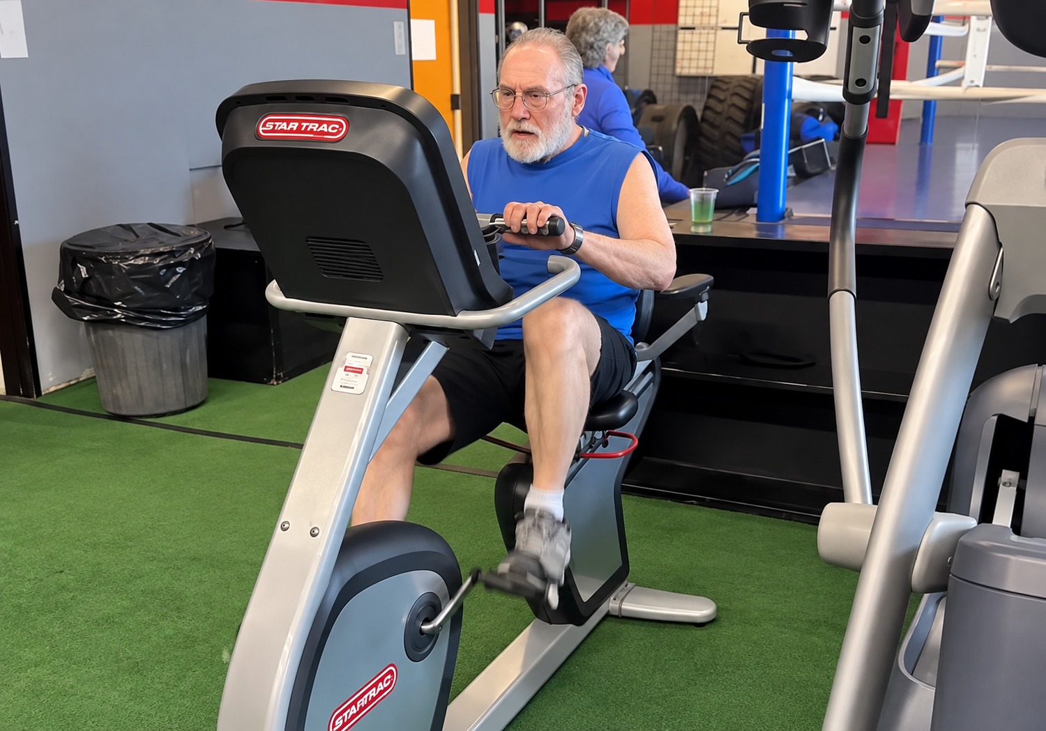 Senior member using a recumbent exercise bike at Battlefit Gym